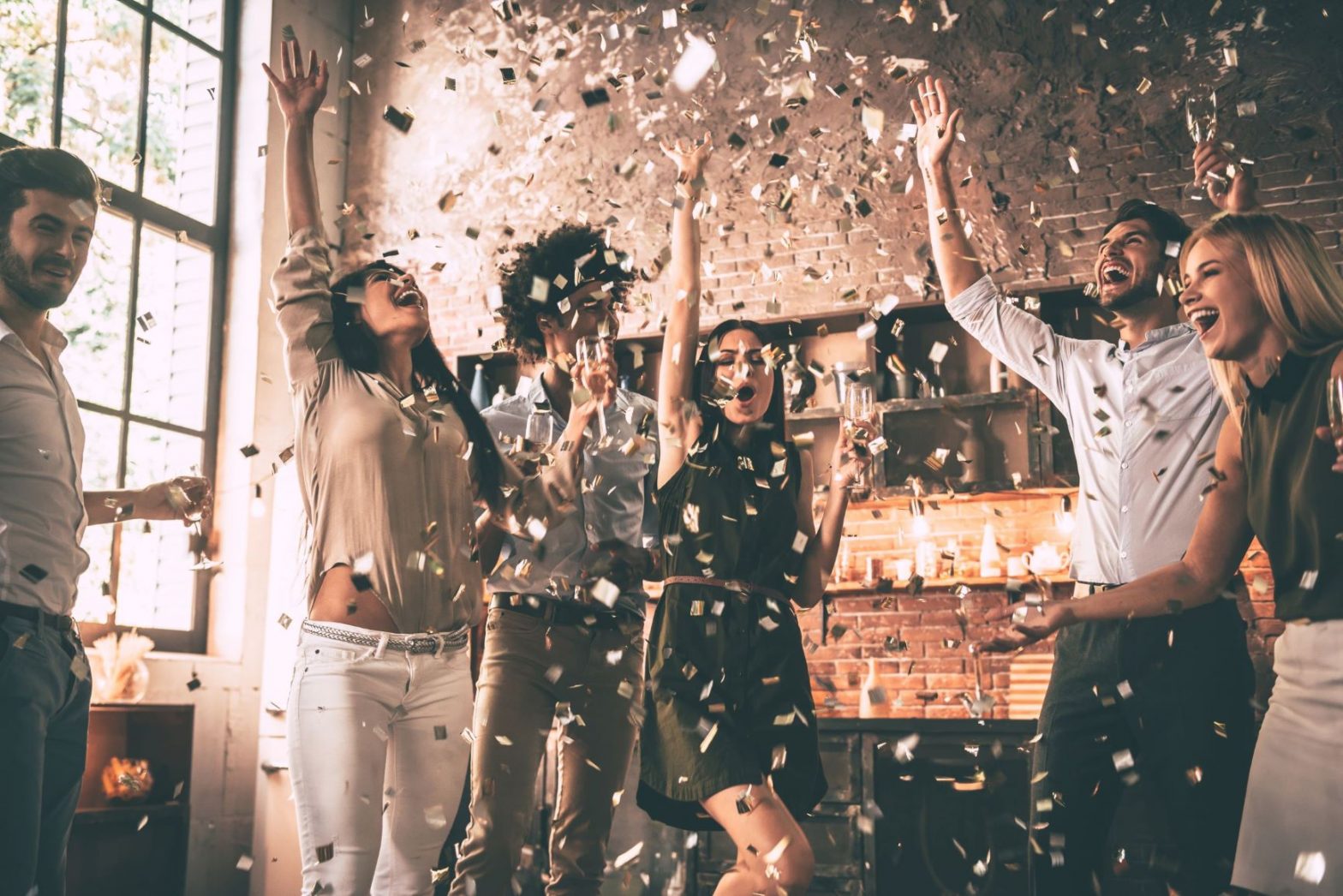 Group of people celebrating a lottery win with confetti and champagne.