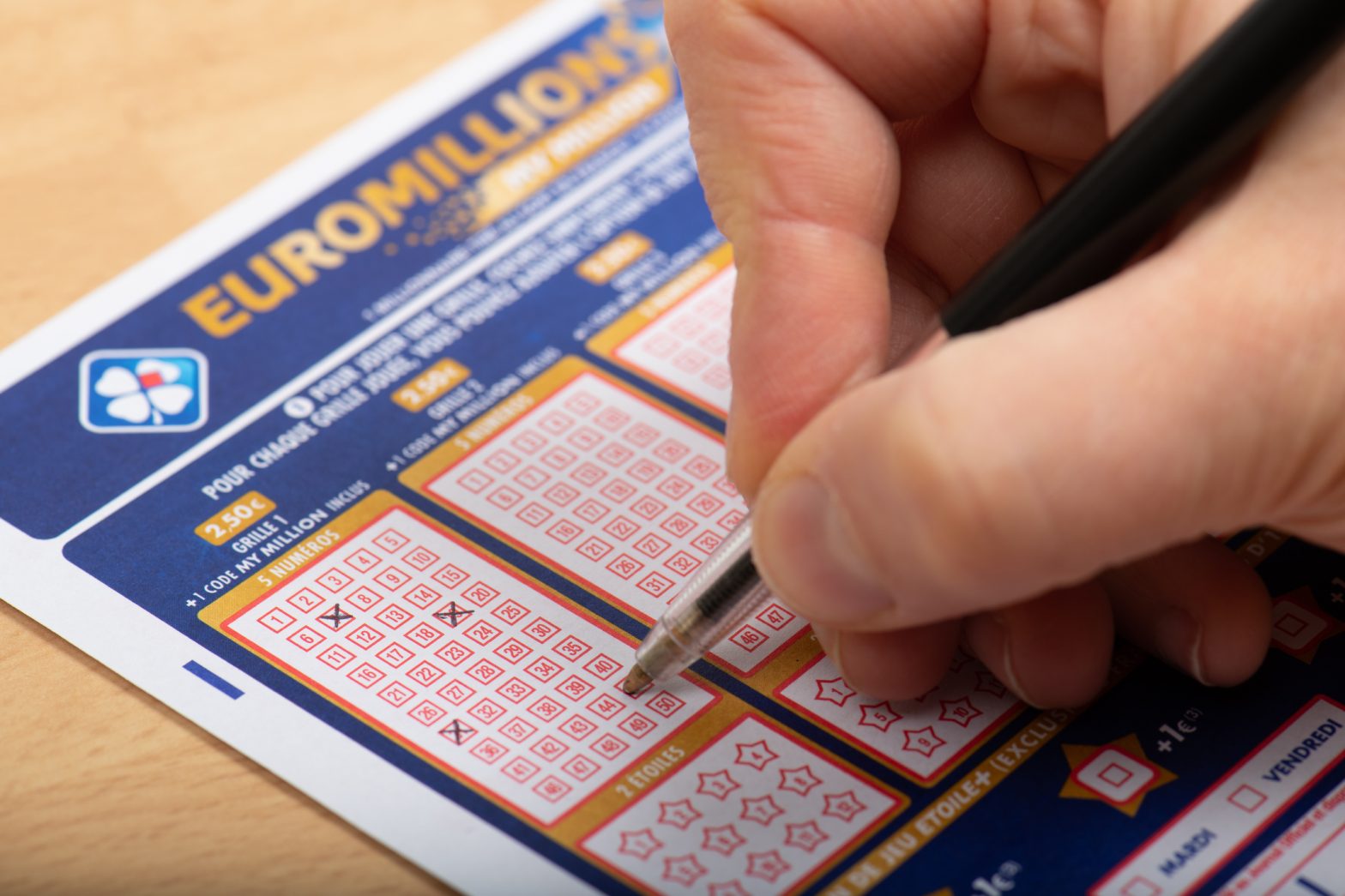 Person filling out EuroMillions ticket