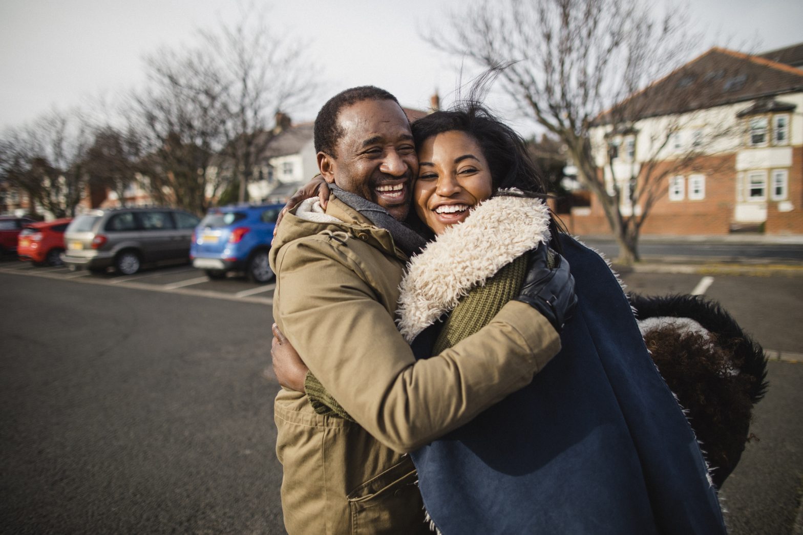 A father happily embracing his daughter as if they had just won the People's Postcode Lottery
